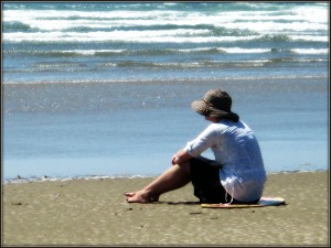 Woman Sits on Beach